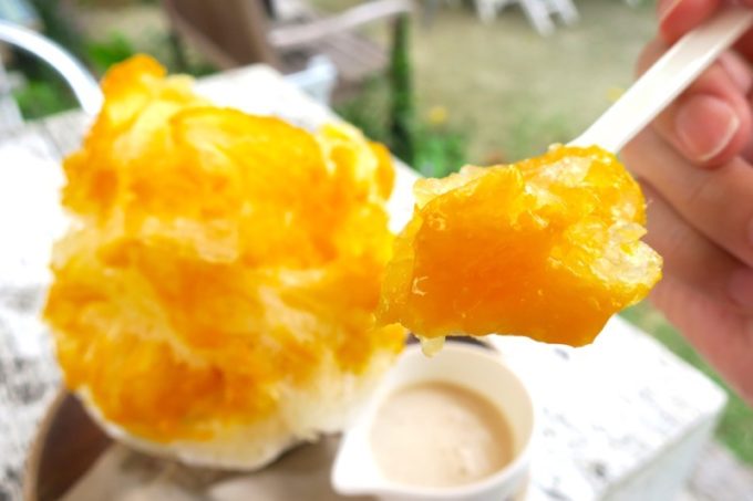 浦添「喫茶ニワトリ」の完熟マンゴー氷のシロップに、果肉がゴロゴロと混ざっている。