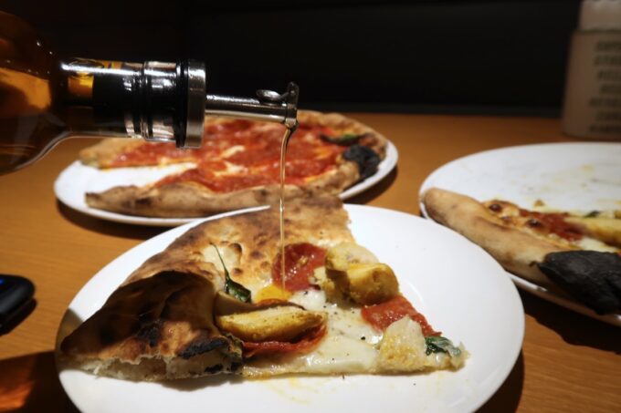 「Pizzeria Bar Ariccia（ピッツエリア バール アリッチャ）」ピザに辛味のオイルをかけていただく
