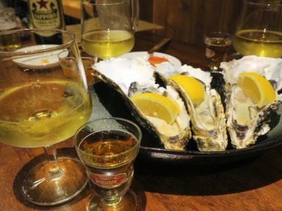 生牡蠣堪能セット（1000円）は、生牡蠣1個とグラスの白ワイン、ウイスキー（ラフロイグ10年）がついてくる。