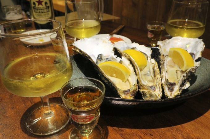 生牡蠣堪能セット（1000円）は、生牡蠣1個とグラスの白ワイン、ウイスキー（ラフロイグ10年）がついてくる。