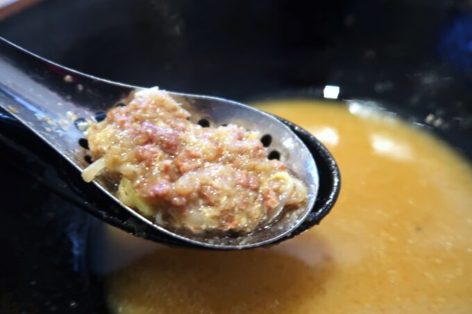 宜野湾「麺恋まうろあ」9月限定麺の味噌・北国は穴あきレンゲで具材をすくう