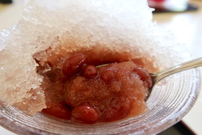 本部町「ドライブインレストランハワイ」冷やしぜんざいの金時豆と氷をかき混ぜて食べやすくする。