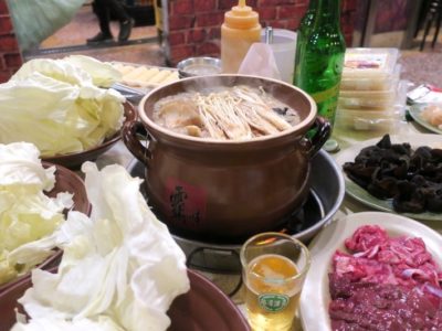 台湾・高雄「現殺霸味薑母鴨」養生セット（1人前TWD600を2セット）や高麗菜（TWD50）などでいっぱいいっぱいのテーブルでグツグツ煮込まれる鴨鍋。