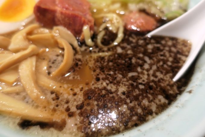那覇・松山「丸麺屋製作所」のブラックこと麻油をスープに溶かし込む