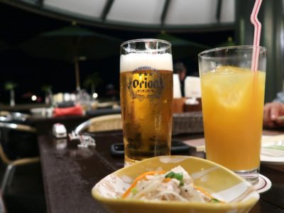 沖縄かりゆしビーチリゾート・オーシャンスパ1階「サンセットテラス（季節営業）」のオリオンビール（750円）とオレンジジュース（550円）