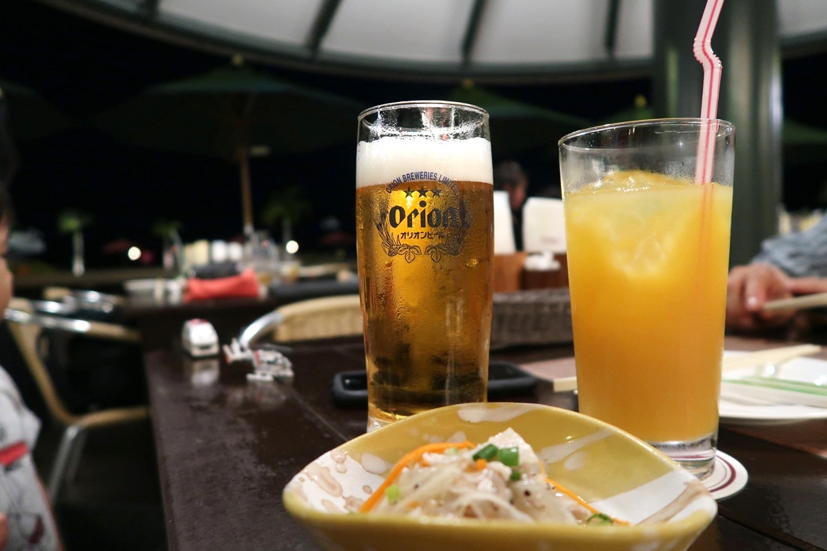 沖縄かりゆしビーチリゾート・オーシャンスパ1階「サンセットテラス（季節営業）」のオリオンビール（750円）とオレンジジュース（550円）