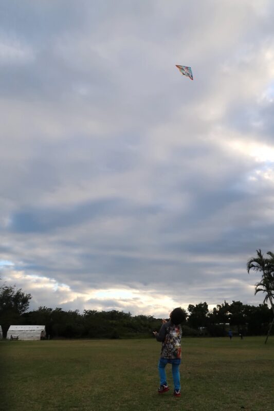 沖縄県金武町「ネイチャーみらい館」の交流広場で凧揚げするお子サマー