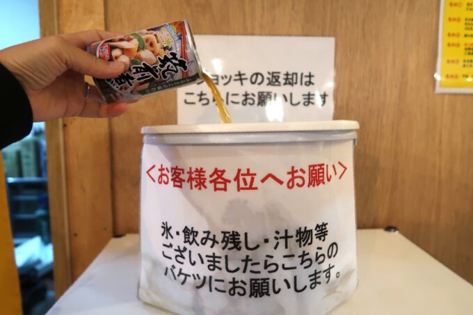 沖縄市・コザの一番街にある「セルフスタンド酒場 勝手にしやがれ」食後に残った汁ものはバケツに捨てる