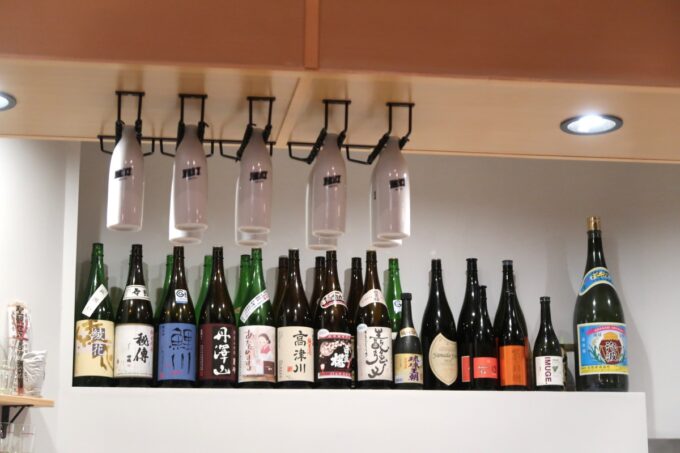 那覇市古島「酒場感」キッチンの上に並ぶ一升瓶