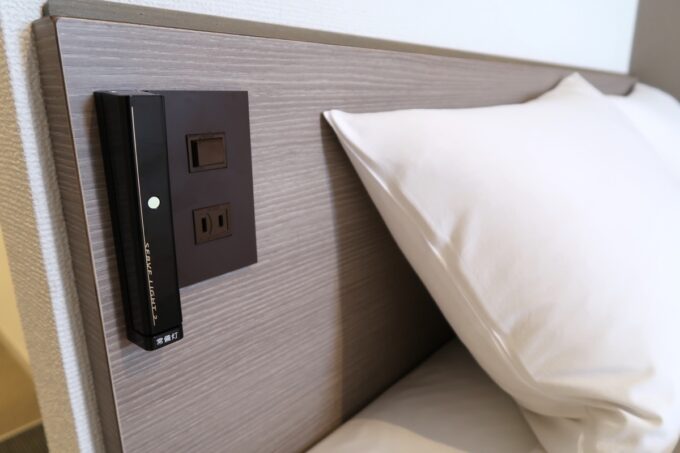 「HOTEL R9 The Yard 宮古島」ダブルルームのベッドの枕元には一般的な電源があった
