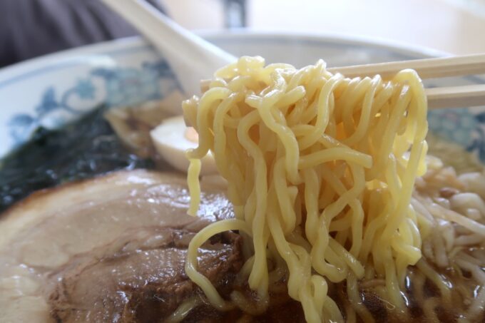 函館「谷地頭温泉」食堂の正油ラーメンのたまご麺を箸上げ