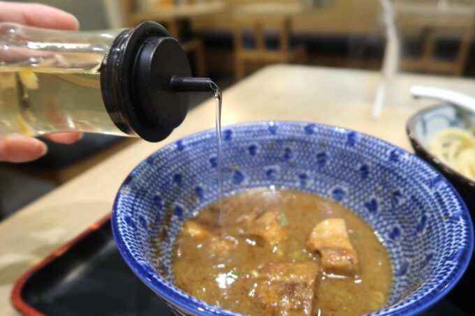 那覇市銘苅「三竹寿」特製濃厚豚骨魚介つけ麺にフルーツ酢をたっぷり入れる