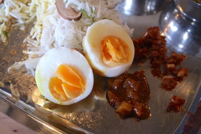 本部町のスパイスカレー店「丸祇羅 沖縄（マルマサラ オキナワ）」に添えられたゆで卵やレモンのピクルスなど