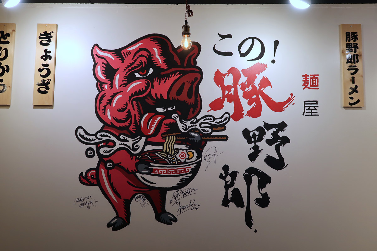 沖縄市のゲート通りにあるラーメン店「麺屋 この！豚野郎」の店内に描かれた豚のイラスト