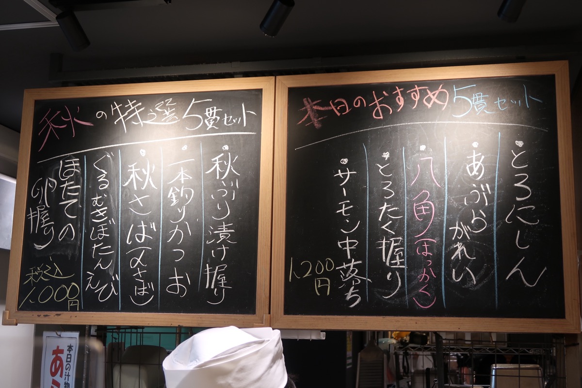 原宿「立食い寿司 根室花まる 神宮前COMICHI店」板さんの頭上にもおすすめメニューがあった