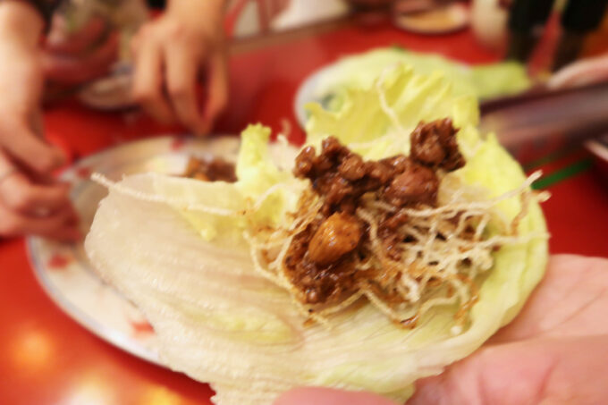 宜野湾市大山「麻婆食堂 福笑い」レタスに味付け濃いめの羊肉を包んで食べる