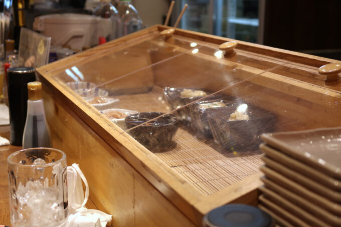 広島市「立吞み 魚椿 袋町店」さっと食べられるおつまみがカウンター上にある