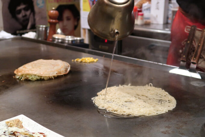 広島市薬研堀「がんちゃん」鉄板の上に麺を丸く広げて焼き上げる