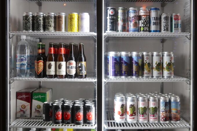 那覇市真嘉比「BEER PARA DINING（ビアパラダイニング）」冷蔵ケースにはボトルや缶のクラフトビールが並ぶ（2023年3月）