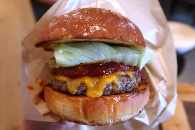 那覇市牧志「Burger Time（バーガータイム）」スタンダードチーズバーガーをバーガー袋に入れる