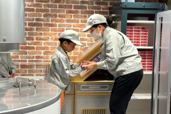 「キッザニア福岡」の石けん工場で成型した牛乳石鹸をもらうお子サマー