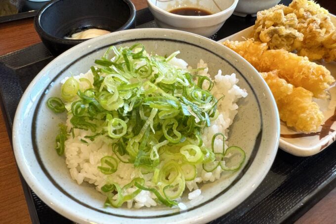 「丸亀製麺 宜野湾」天ぷらを盛り付けるごはんの上に無料のネギを敷いた