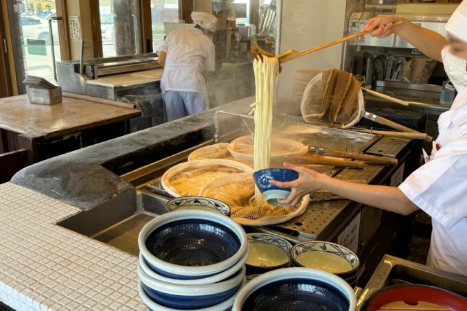 「丸亀製麺 宜野湾」茹でたてのうどんを計る店員さん