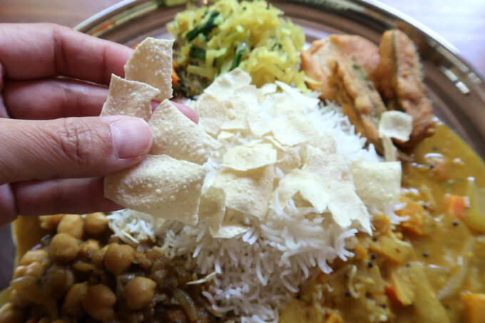 本部町「スーリヤ食堂」南インドカレー定食のパパドを砕いて振りかける