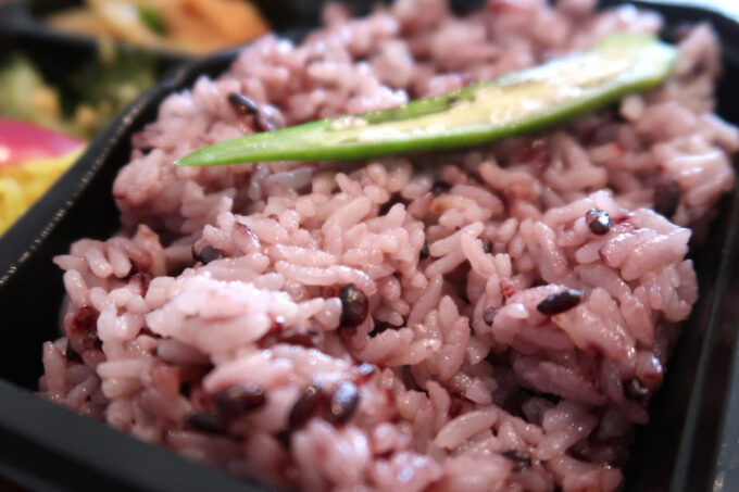 糸満市「お弁当屋ペッコペッコ」タルタルソースが載せられた鮭南蛮の黒米入りごはん