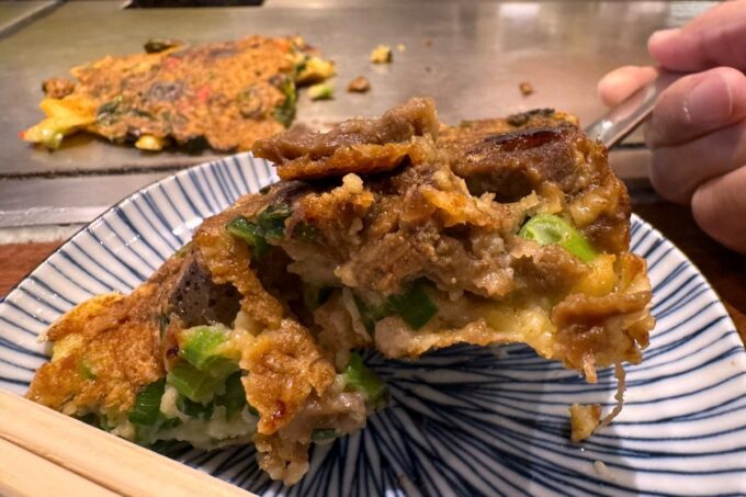 大阪「ねぎ焼 やまもと 梅田エスト店」カットしたすじねぎ焼きを小皿に取り分ける
