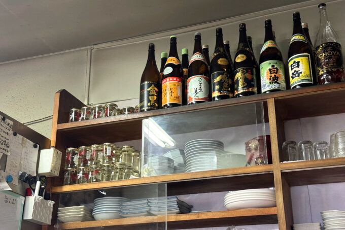 福岡市「弥太郎うどん」店内の食器棚上に置かれた一升瓶