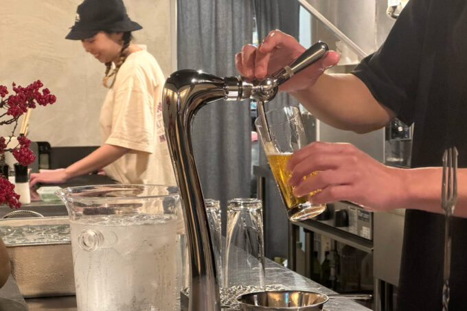 宮古島のビアバー「短パン日和」のウチダさんにビールを注いでもらう