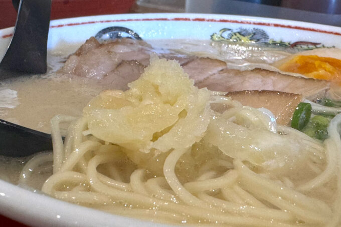 豊見城市「豚骨ラーメン まる・安」豚骨ラーメンに潰した生ニンニクを入れる